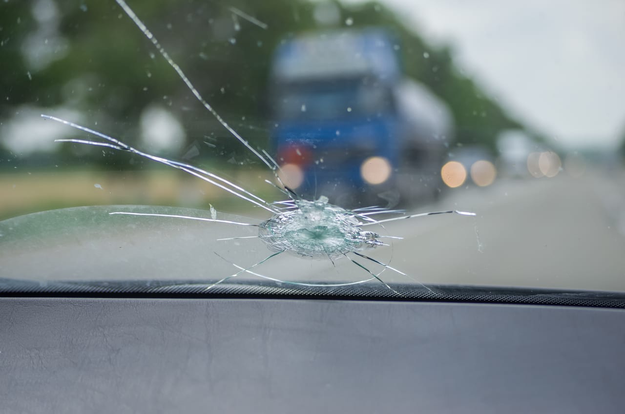 Impact de gravillon reçu sur autoroute derrière un camion